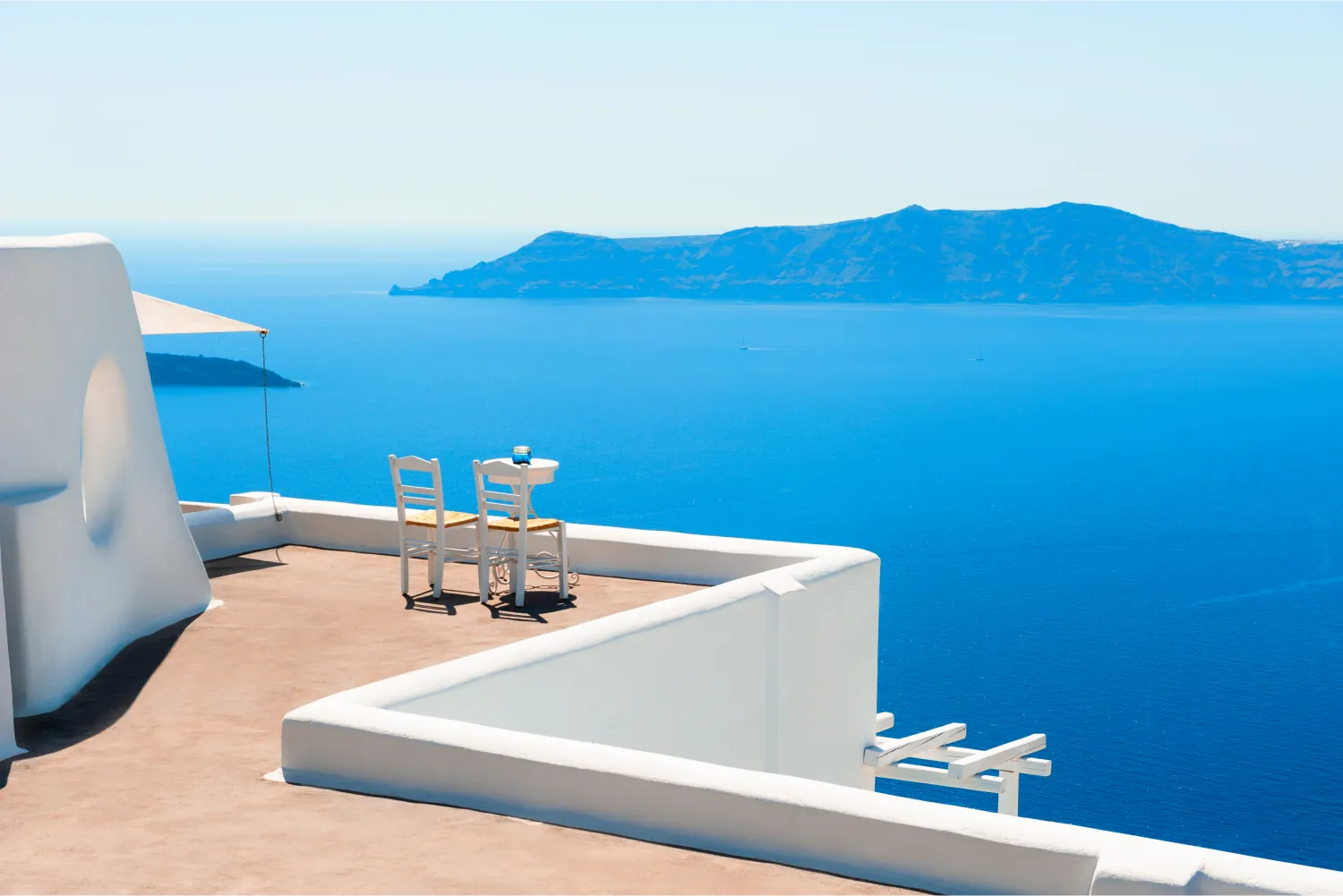 Deux chaises sur la terrasse avec vue sur la caldeira à Santorin