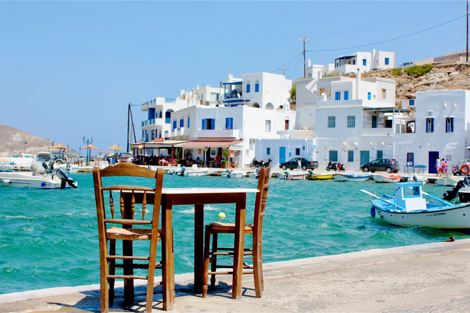 Une table pour deux attend un client dans un port pittoresque de Tinos