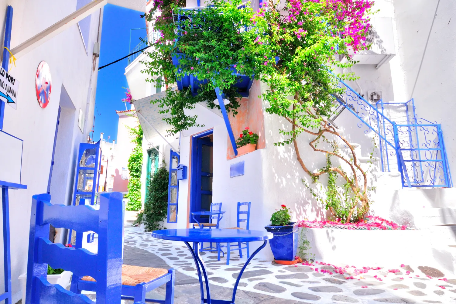 Murs blancs, meubles bleus et bougainvillier coloré dans le village de Skiathos